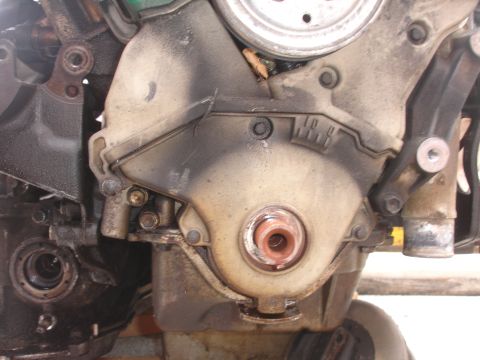 1993 Ford Taurus - Close-up of an engine's timing cover, showing mechanical components and signs of wear.