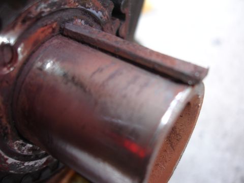 1993 Ford Taurus - Close-up view of a rusted metal pipe with an attached bracket, likely a component from a vehicle's exhaust system.