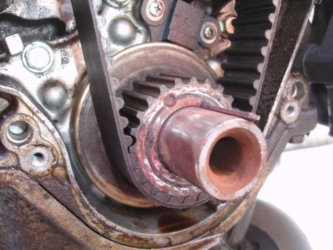 1993 Ford Taurus - Close-up view of a worn engine timing belt and pulley assembly.