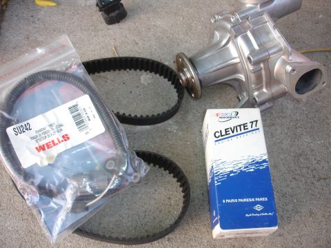 1993 Ford Taurus - New engine parts laid out on a concrete surface, including a water pump and belts.