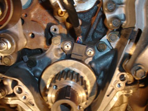 1993 Ford Taurus - Close-up of an engine's crankshaft position sensor and toothed wheel assembly.