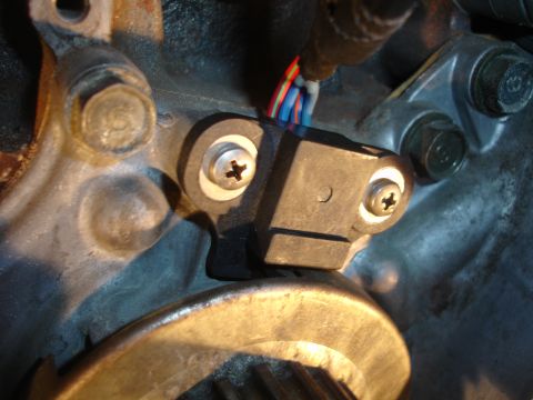 1993 Ford Taurus - Close-up view of a crankshaft position sensor attached to an engine block, with wiring visible.