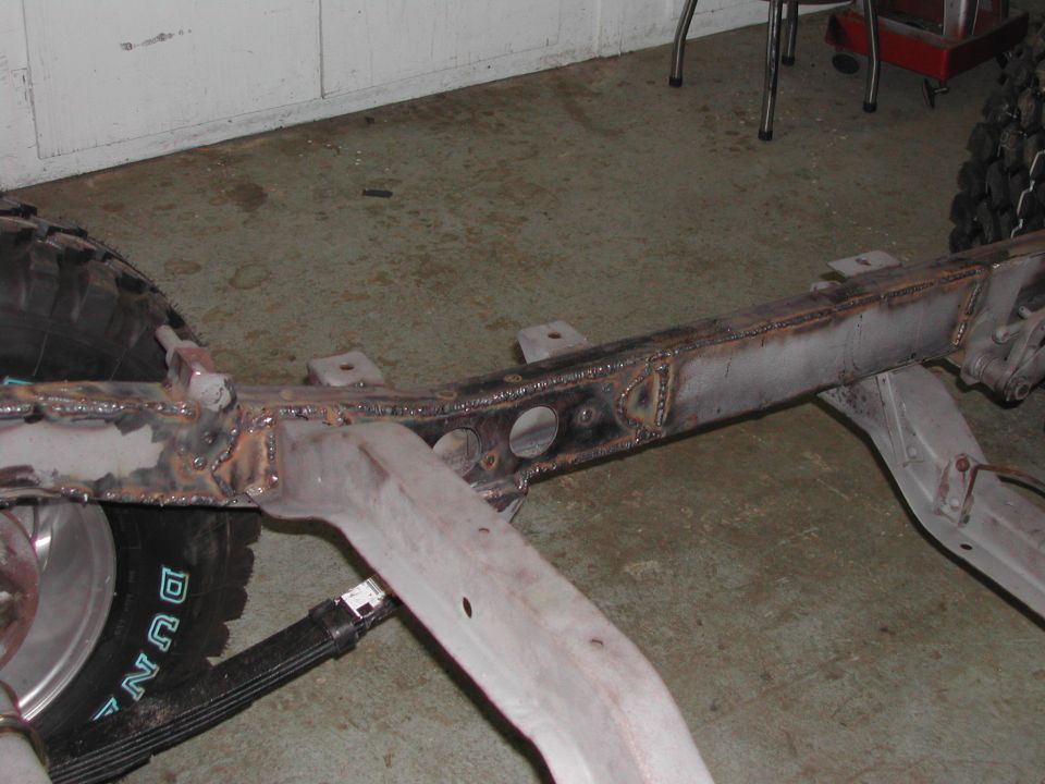 Vehicle frame with welds and a tire visible