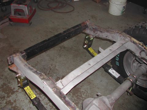 1948 Jeep Wrangler - Close-up view of a vehicle frame, possibly undergoing repair or restoration, with visible straps and a tire.