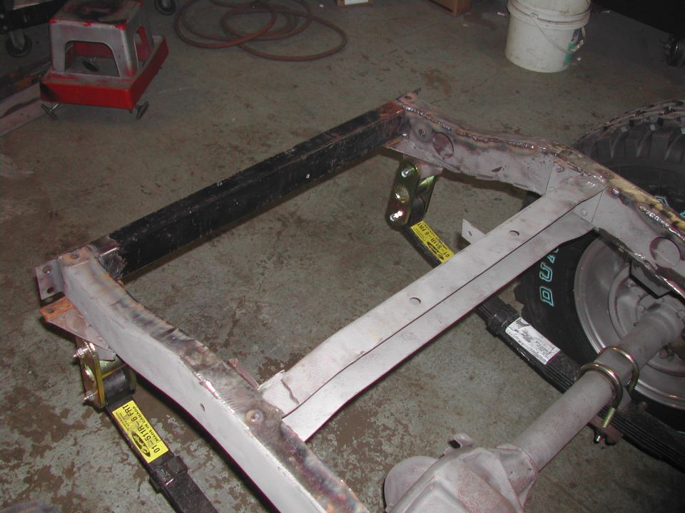 Vehicle frame with yellow straps and part of a tire visible