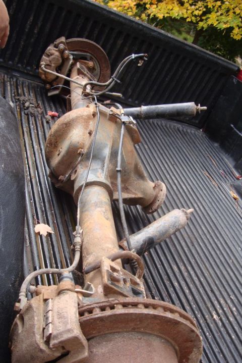 1996 Ford Bronco - Rear axle assembly with shocks and brake calipers, likely removed from a vehicle.