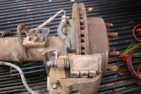 1996 Ford Bronco - This rusty brake assembly, possibly a Dana 60 rear, is shown in detail, with visible markings on the caliper.