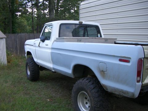 1988 Ford Bronco - This Ford pickup truck, likely from the 1970s, is shown from the side with a two-tone paint scheme and off-road tires.