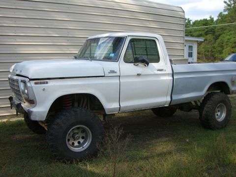 1988 Ford Bronco - This lifted pickup truck has a two-tone paint scheme and large off-road tires.
