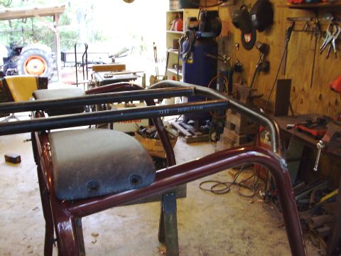 1995 Ford Bronco - A custom roll cage with seats is shown in a workshop setting, with various tools and equipment visible.