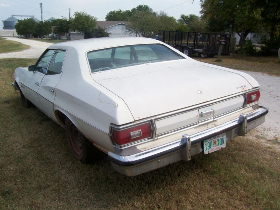 View of the left rear of the car, notice the fiberglass inserts between the bumper and the body are all there (if slightly squished on one side) and the vinyl is missing on one molding.  There are also a couple of deep scratches (now rusted in) that I can sand, primer, refill, and blend.