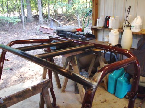 1995 Ford Bronco - A custom roll cage, likely for an off-road vehicle, is shown mounted on sawhorses in a workshop setting.