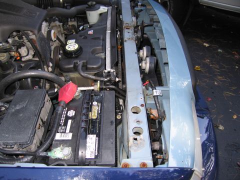 1991 Ford LTD Crown Victoria - Close-up view of a vehicle's engine bay, highlighting the battery and radiator assembly.