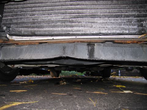 1991 Ford LTD Crown Victoria - Undercarriage view shows the vehicle's radiator and a damaged lower bumper section.