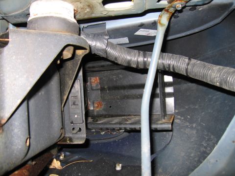 1991 Ford LTD Crown Victoria - Detail of wiring and bracketry in an engine compartment, showing rust and wear.
