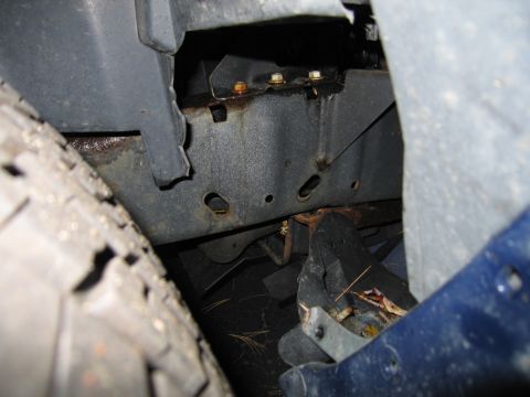 1991 Ford LTD Crown Victoria - The underside of a vehicle shows rust on the frame and suspension components.