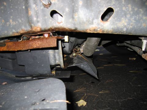 1991 Ford LTD Crown Victoria - The undercarriage of a vehicle displays significant damage to its plastic components and frame.