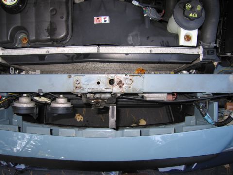 1991 Ford LTD Crown Victoria - Front end view of a vehicle's engine bay, showing the radiator, horns, and coolant reservoir.
