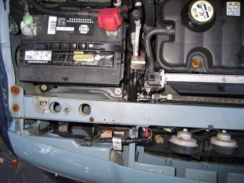 1991 Ford LTD Crown Victoria - Close-up of a car's engine bay, the battery, coolant reservoir, and horns.