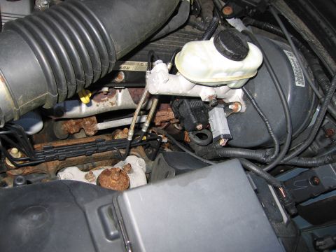 1991 Ford LTD Crown Victoria - Close-up of brake booster and master cylinder assembly in an engine bay.