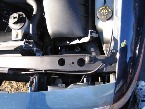 1991 Ford LTD Crown Victoria - Close-up view of a vehicle's engine bay, highlighting the washer fluid reservoir and various hoses and components.