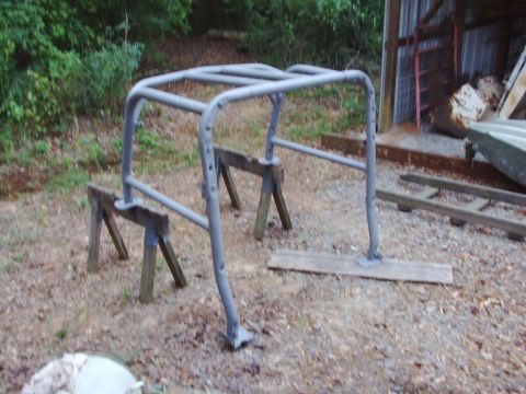 1995 Ford Bronco - A gray metal roll cage is supported by wooden sawhorses in an outdoor setting.