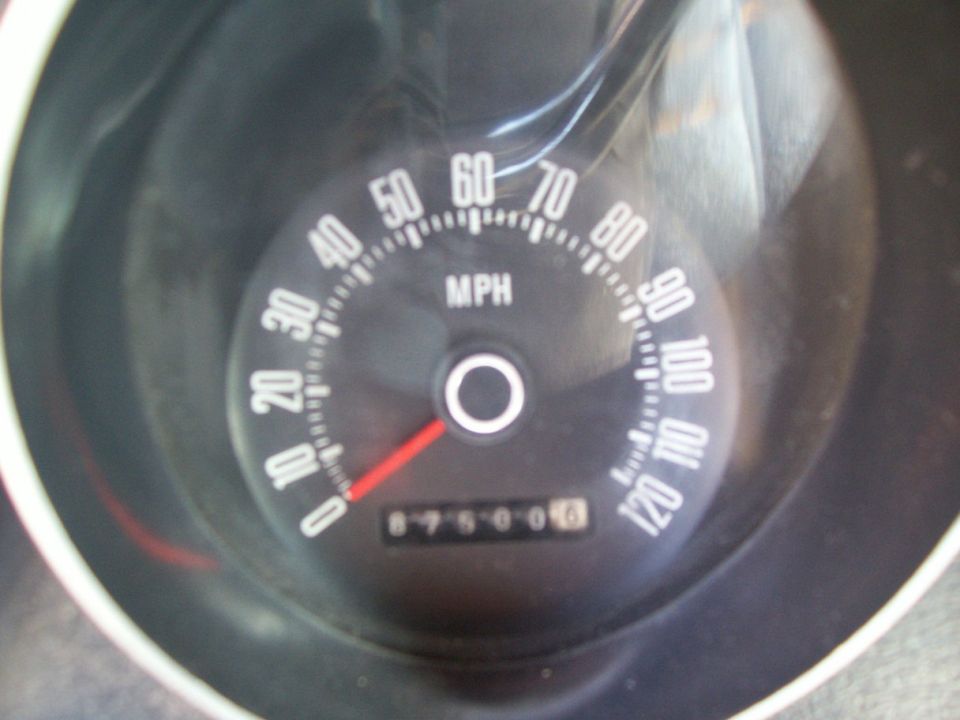 Vintage analog speedometer reading 120 MPH max with odometer near 87500 miles