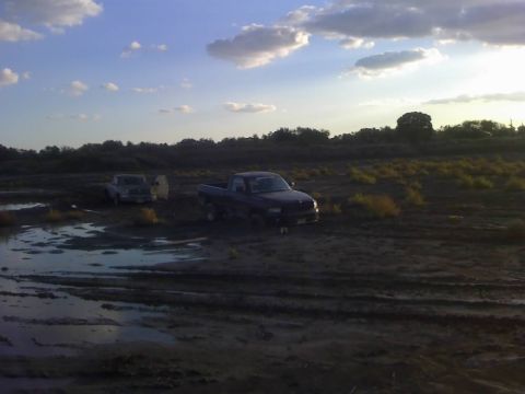 1996 Dodge 1500 - A 1996 Dodge 1500 pickup truck navigates a muddy off-road terrain with another truck visible in the background.