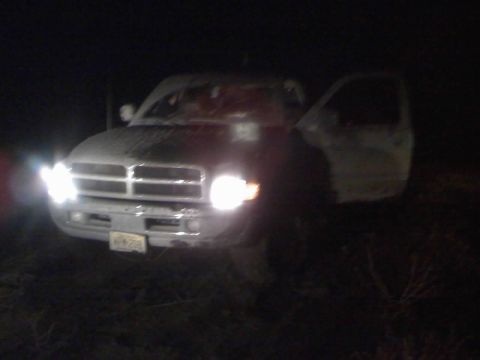 1996 Dodge 1500 - A Dodge Ram pickup truck is parked at night with its headlights and driver's side door illuminated.