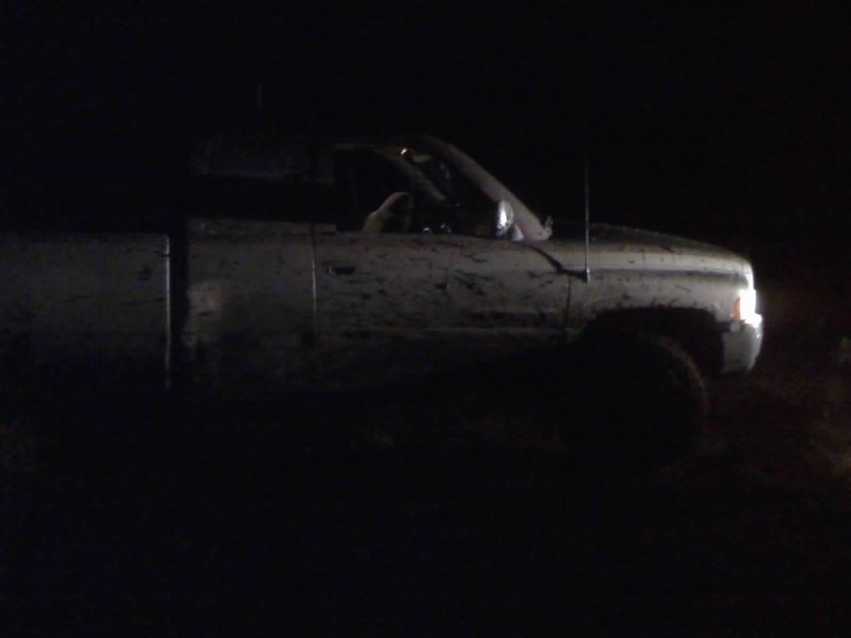 Mud-splattered 1996 Dodge 1500 pickup truck, 3q front view at night