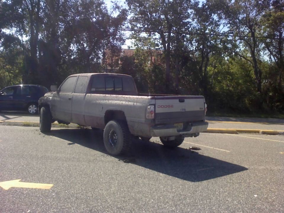 Dodge Ram pickup truck parked on asphalt with trees in background