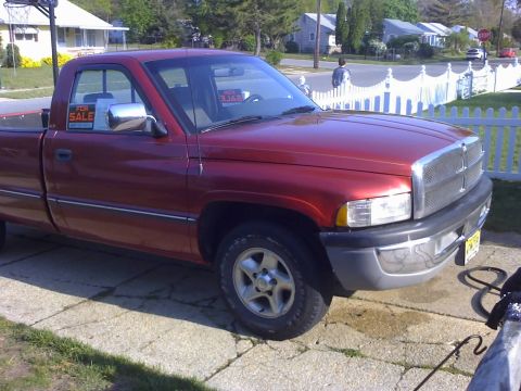 1996 Dodge 1500 - This red 1996 Dodge 1500 pickup truck is shown from a 3q-front angle, with a "For Sale" sign visible in the driver's side window.