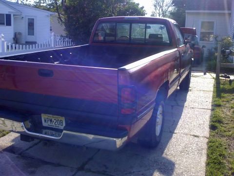 1996 Dodge 1500 - Rear view of a red 1996 Dodge 1500 pickup truck parked in a residential driveway.