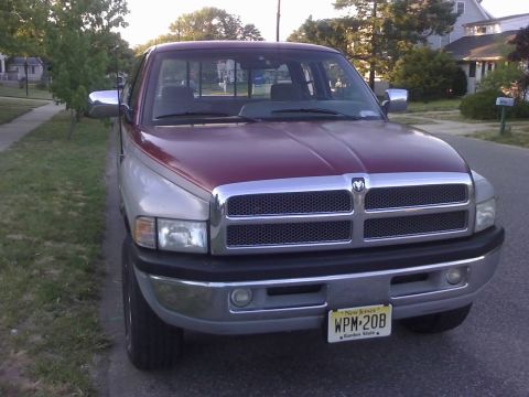 1996 Dodge 1500 - This Dodge Ram pickup truck has a two-tone paint job and a prominent chrome grille.