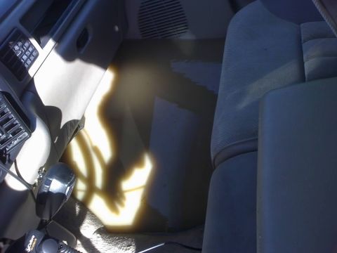 1996 Dodge 1500 - The interior of a vehicle shows significant water damage on the floor and lower seat areas.