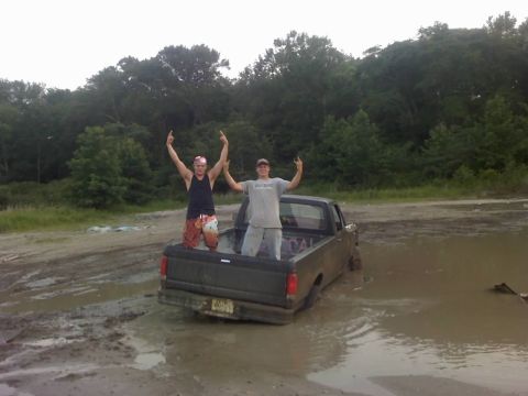 1996 Dodge 1500 - Two men celebrate while their pickup truck is stuck in a muddy area.