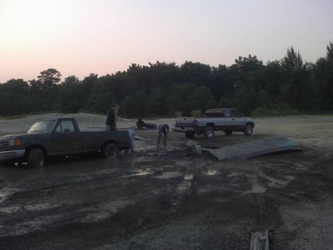 1996 Dodge 1500 - Two trucks are stuck in the mud, with people attempting to free them.