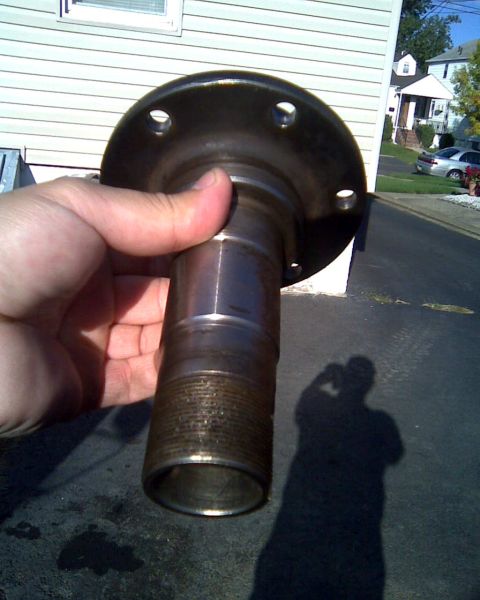 1989 Ford Bronco - A metal hub assembly part is held up for inspection, with a house and street visible in the background.
