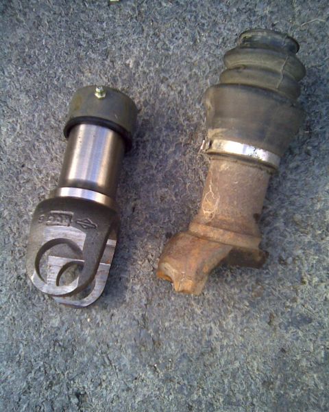 1989 Ford Bronco - Two automotive parts, likely from a steering or suspension system, are shown resting on a textured surface.