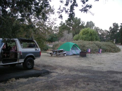 1991 Ford Bronco - A Ford Bronco is parked at a campsite with a tent and picnic table.