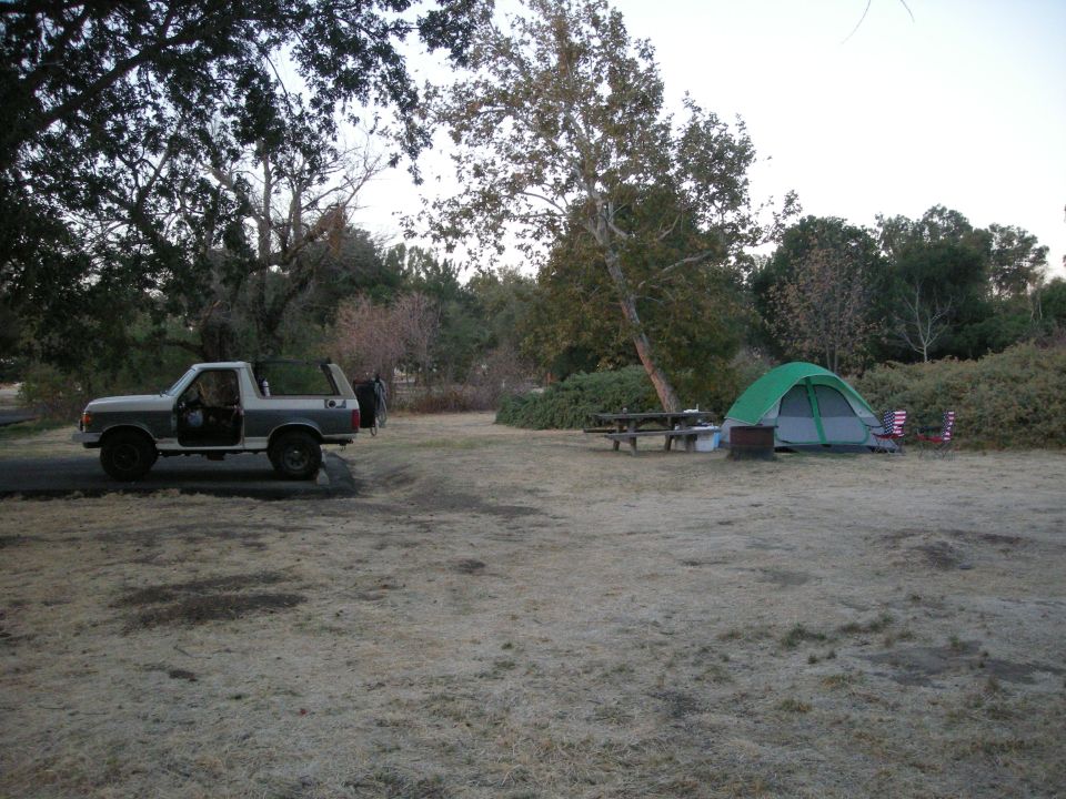 Two-tone SUV with removable top parked at campsite