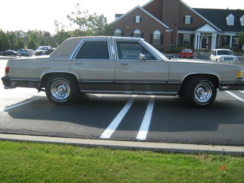 1988 Mercury Grand Marquis - A tan 1988 Mercury Grand Marquis sedan is parked in a lot on a sunny day.