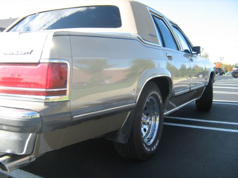 1988 Mercury Grand Marquis - Rear view of a 1988 Mercury Grand Marquis with a tan vinyl roof and chrome trim.