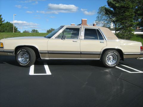 1988 Mercury Grand Marquis - Side view of a 1988 Mercury Grand Marquis sedan parked in a lot.