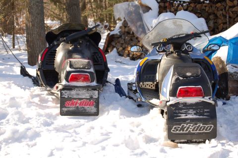 1991 Ford Probe - Two Ski-Doo snowmobiles are parked in the snow, viewed from the rear.