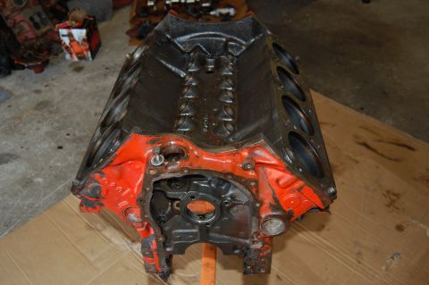 1994 Ford Bronco - Engine block shown from the front, with orange painted end caps and black metal casing.