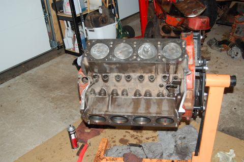 1994 Ford Bronco - An engine block is mounted on an orange engine stand in a garage setting.