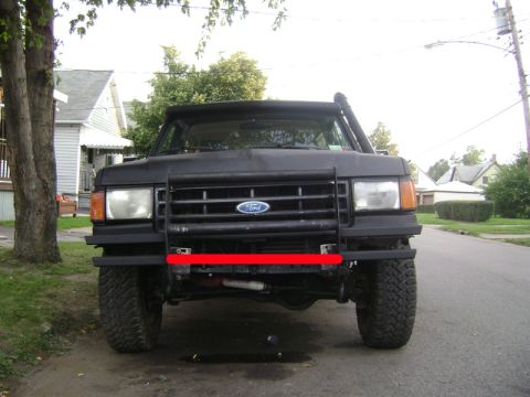 1987 Ford Bronco - Front view of a black 1987 Ford Bronco, equipped with a bull bar and snorkel, parked on a residential street.