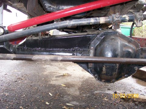 1984 Ford Bronco - Close-up shot of the front axle and suspension system of an off-road vehicle.