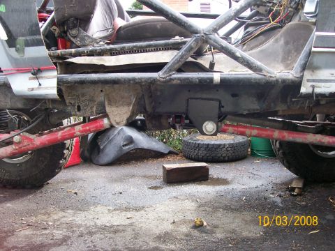 1984 Ford Bronco - The underside of a heavily modified vehicle shows extensive roll cage and suspension work.
